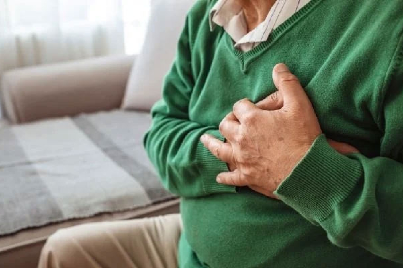 Pessoa com dor no peito segurando a região do tórax